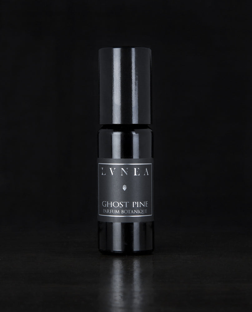10ml black glass bottle of LVNEA's best-selling Ghost Pine roll on perfume on black background