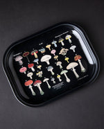 Black enameled metal tray with vintage-style illustrations of mushrooms on it.
