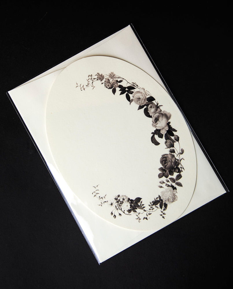 cream coloured oval greeting card bordered with black and grey photo-realistic illustrations of roses