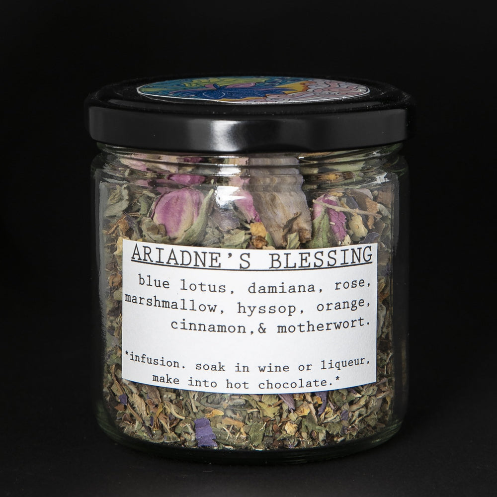 Clear glass jar with black screw top lid containing blueberryjams' "Ariadne's Blessing" herbal tea blend
