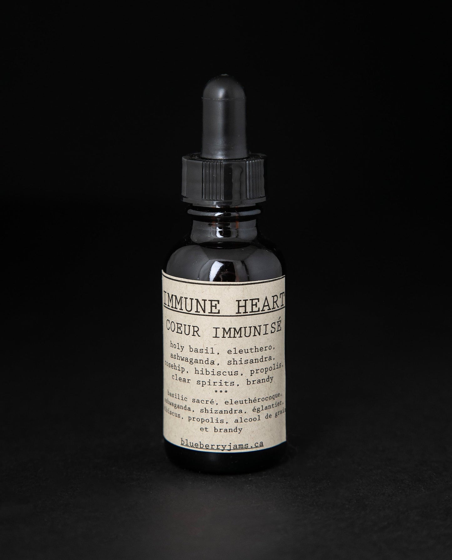Black glass bottle with dropper top of blueberryjams "Immune Heart" herbal tincture.