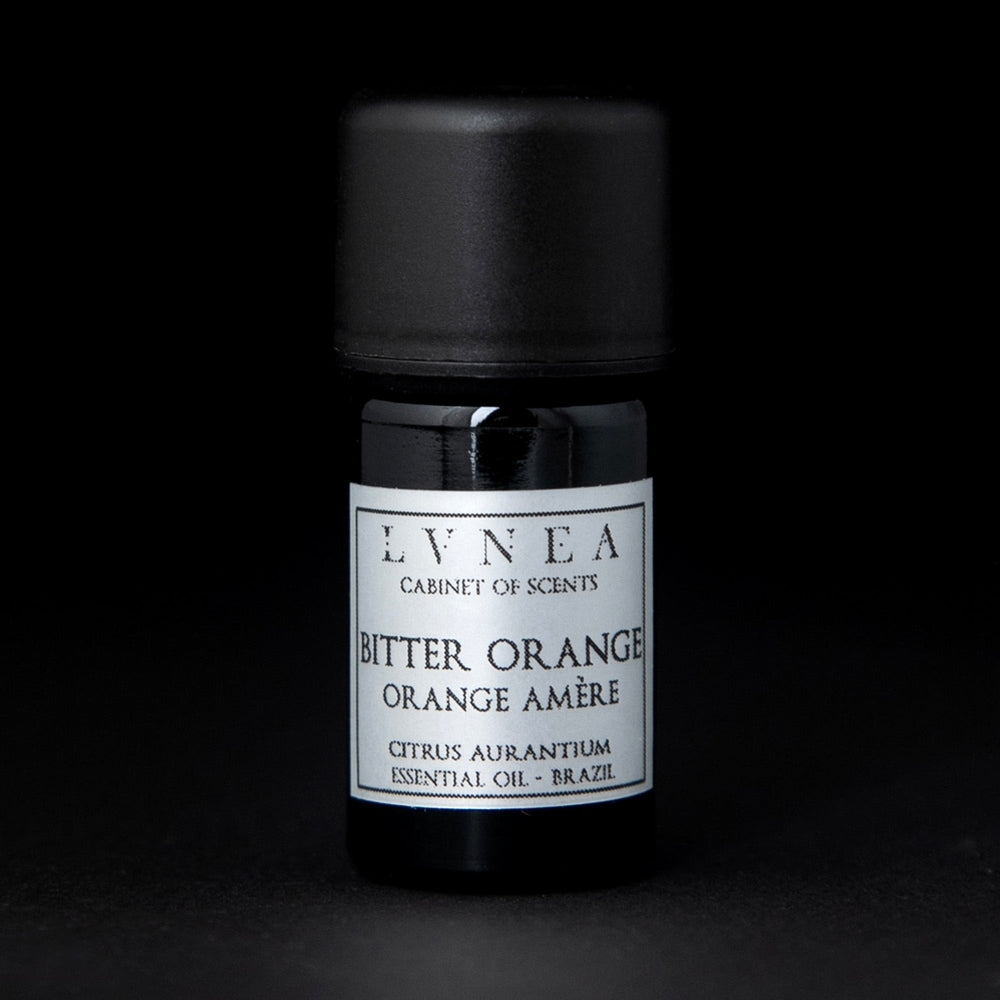 5ml black glass bottle of LVNEA's bitter orange essential oil on black background. The bottle has a silver label.