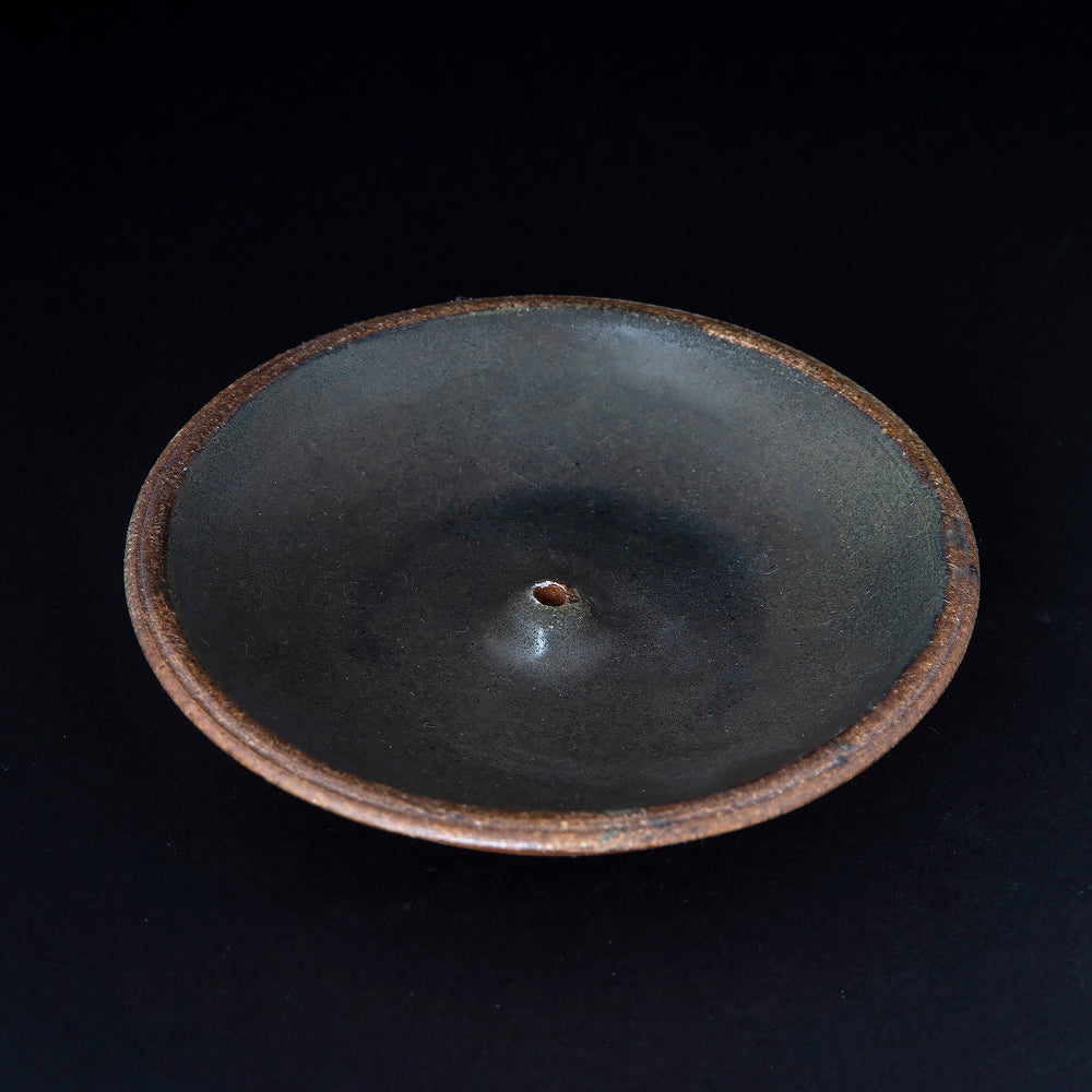 matte black glazed stoneware incense holder on black background