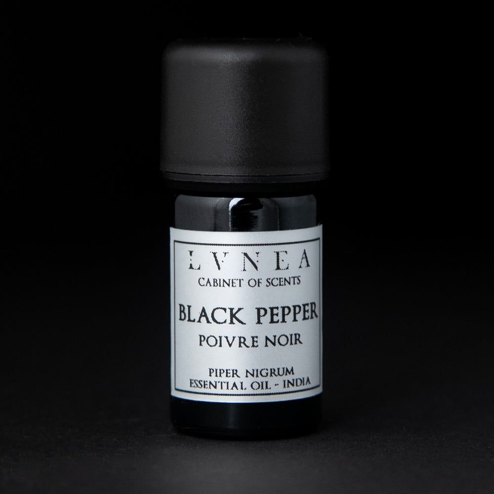 5ml black glass bottle of LVNEA's black pepper essential oil on black background. The label on the bottle is silver.