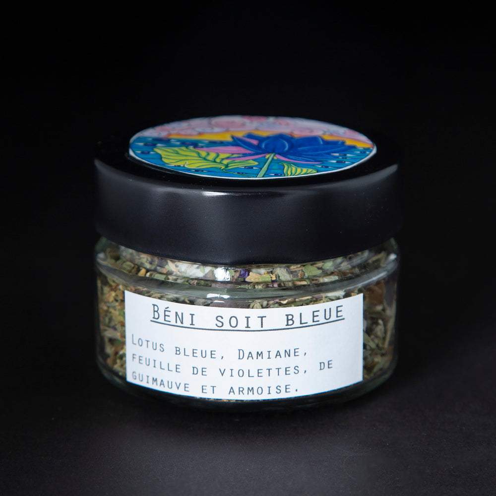 Clear glass jar with black lid containing a blue lotus herbal rolling blend. The white label reads "Béni Soit Bleue"