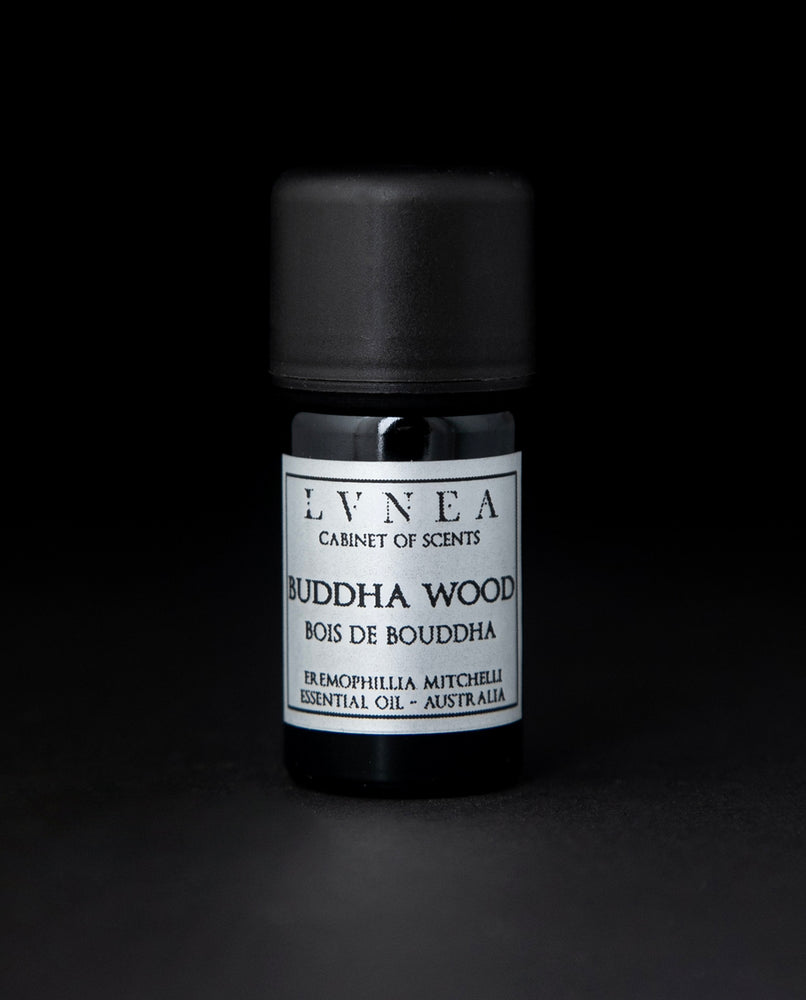 5ml black glass bottle with silver label of LVNEA's Buddha Wood essential oil on black background.