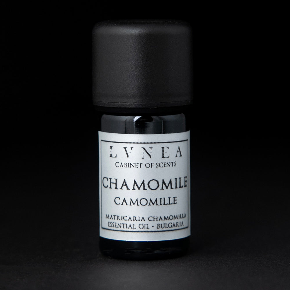 5ml black glass bottle with silver label of LVNEA's chamomile essential oil on black background