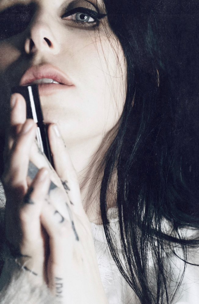 
                      
                        Singer songwriter Chelsea Wolfe cradles a bottle of her collaborative fragrance with natural and botanical perfume brand LVNEA, Pêche Obscène.
                      
                    