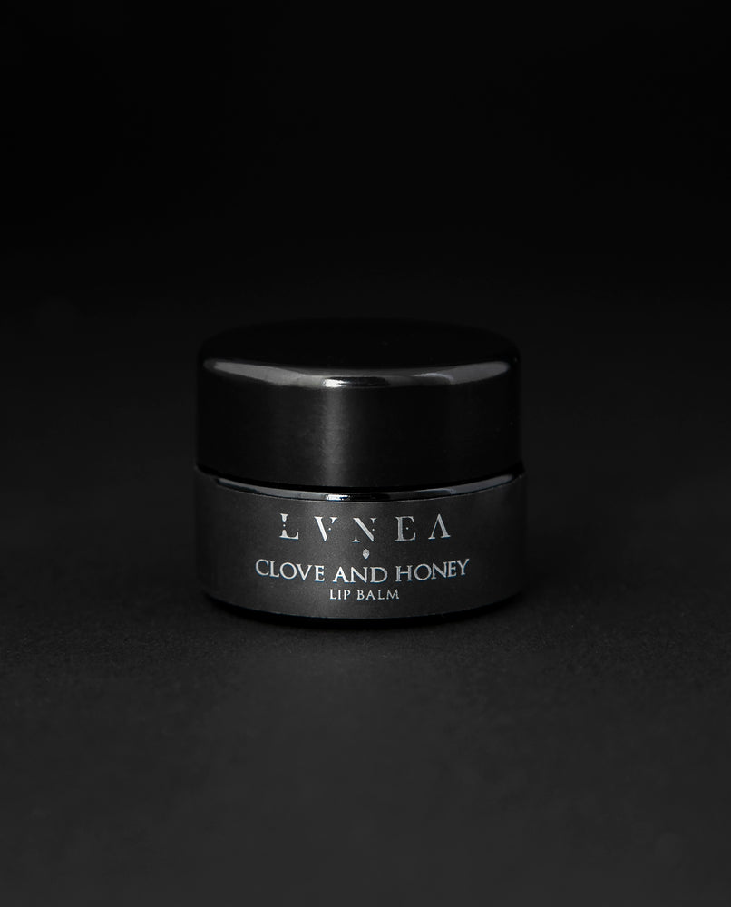 5g black glass pot of LVNEA's Clove and Honey lip balm on black background