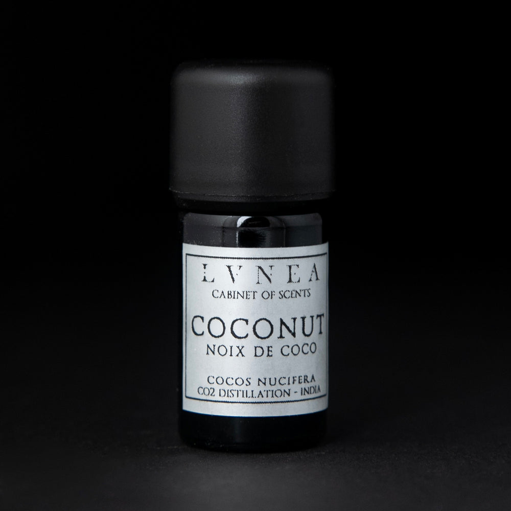 5ml black glass bottle with silver label of LVNEA's coconut essential oil on black background