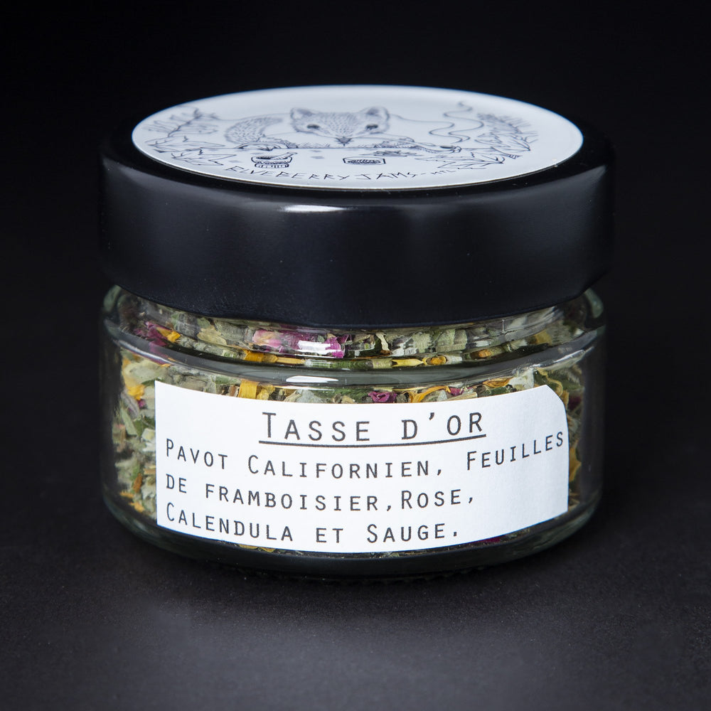 
                      
                        Clear glass jar with black lid containing blueberryjams' "Cup of Gold" rolling blend. French label reading "Tasse d'Or" is visible.
                      
                    