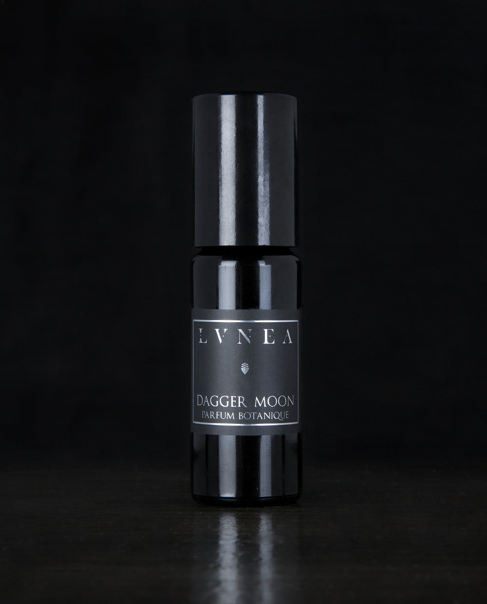10ml black glass bottle of LVNEA's Dagger Moon natural roll on perfume oil on black background