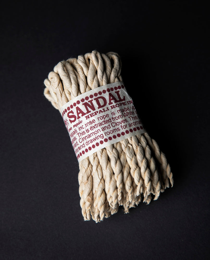 Bundle of sandalwood rope incense wrapped together with cream paper label.
