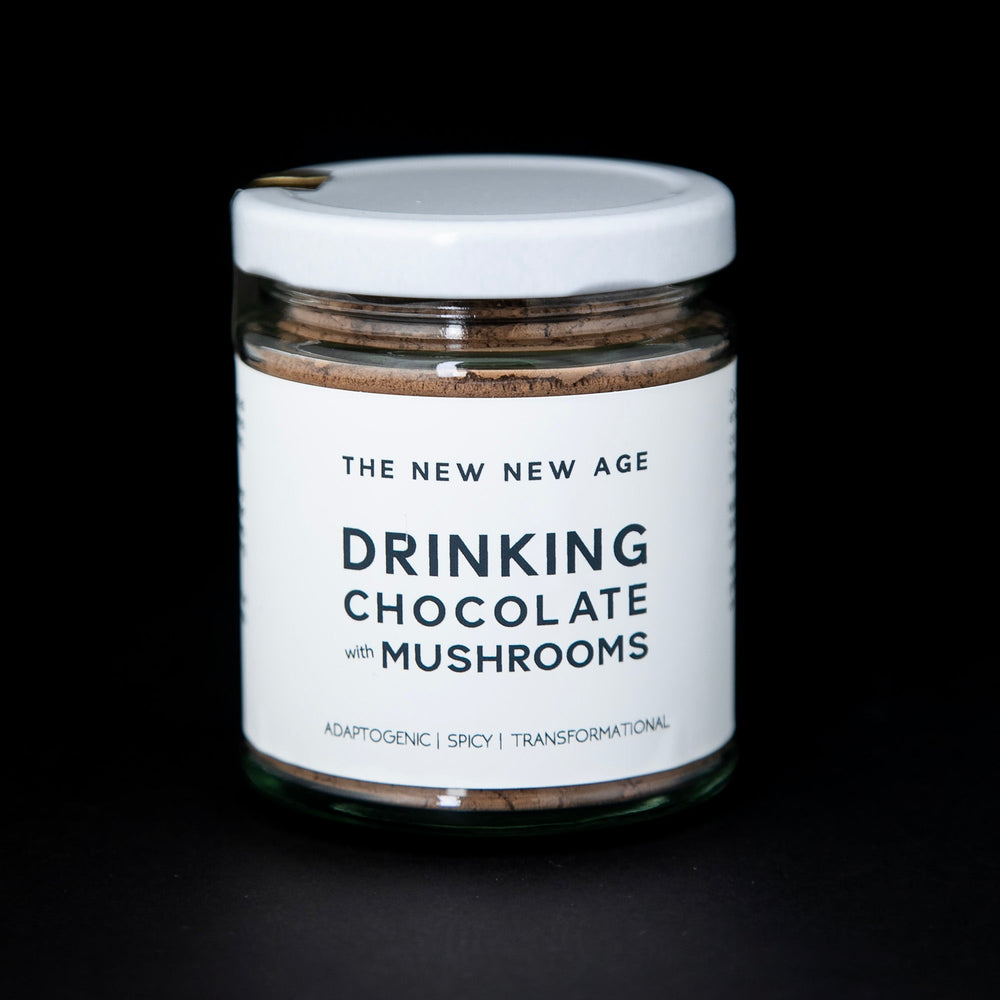 clear glass jar with white lid and white label filled with The New New Age's "Drinking Chocolate with Mushrooms"