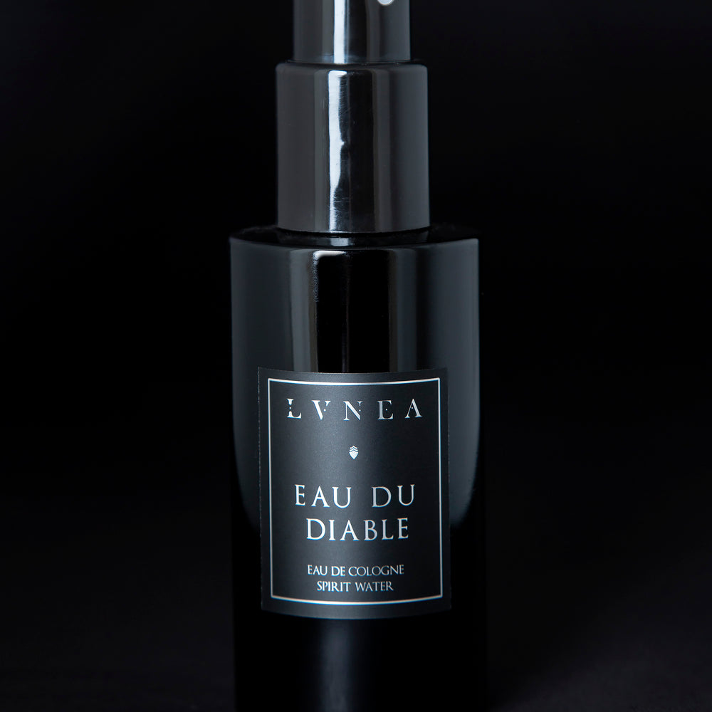 100ml black glass bottle of LVNEA’s Eau du Diable natural fragrance on black background