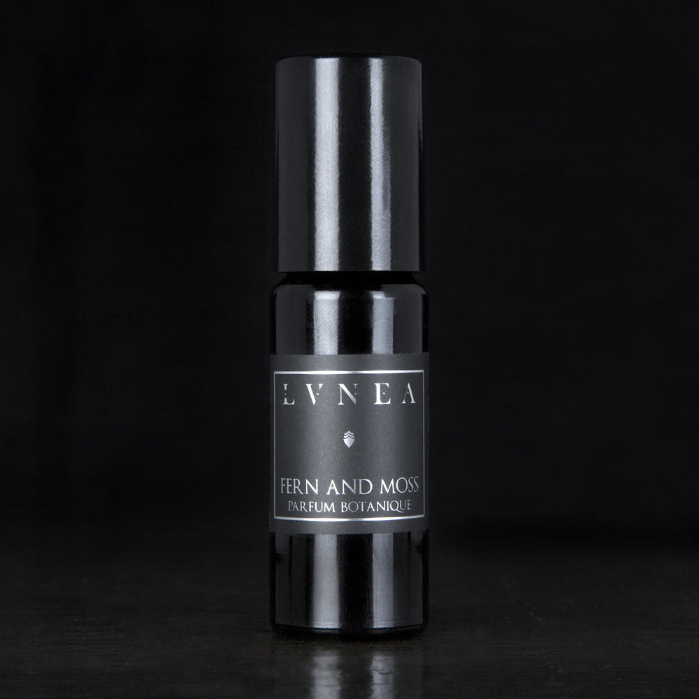 10ml black glass bottle of LVNEA's Fern and Moss natural roll on perfume oil on black background