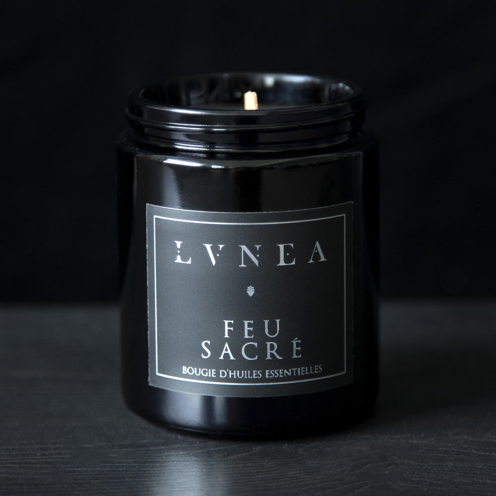 LVNEA’s Feu Sacré candle housed in a resealable 8 ounce black glass jar on a black background