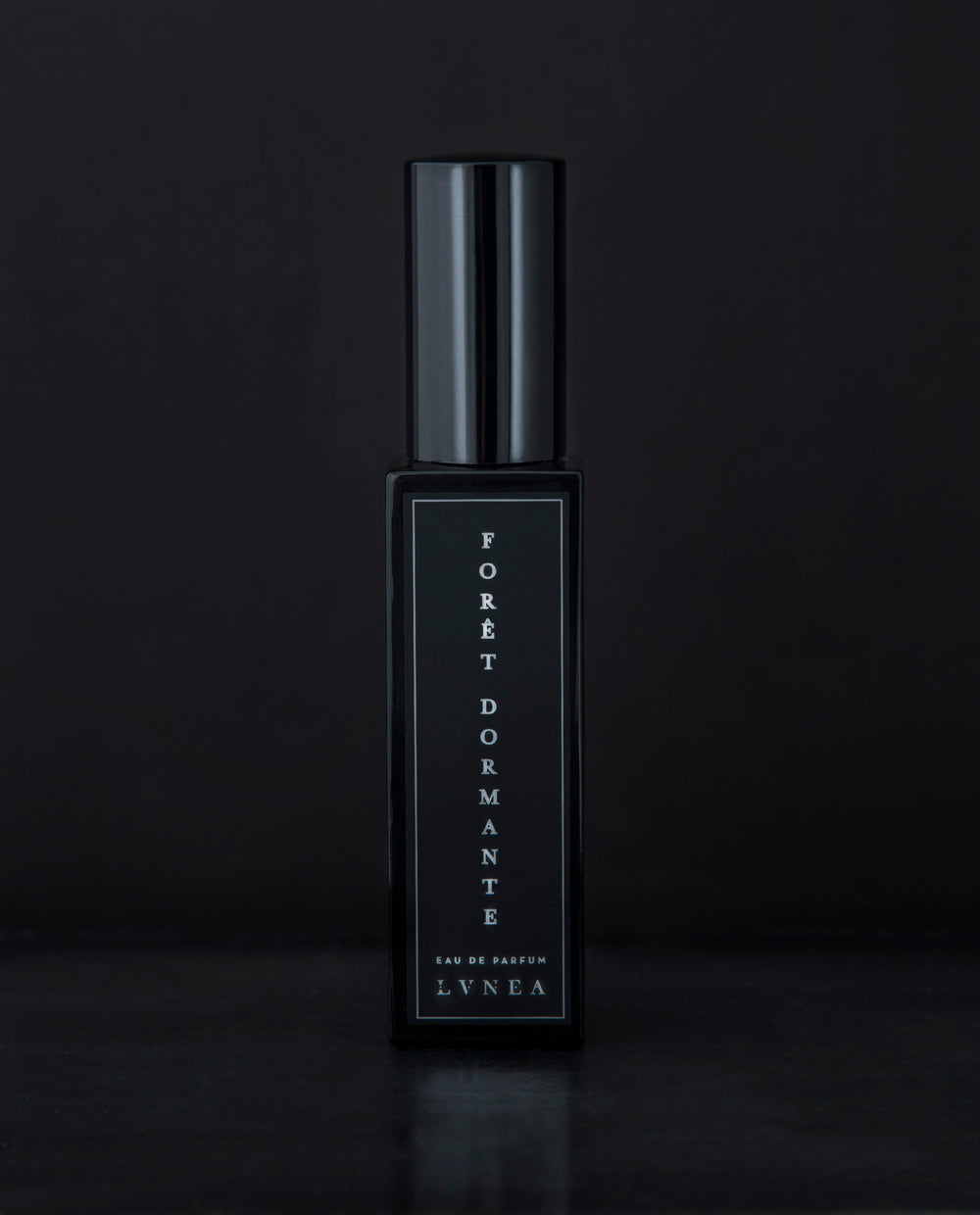 30ml black glass bottle of LVNEA’s Forêt Dormante natural perfume on black background