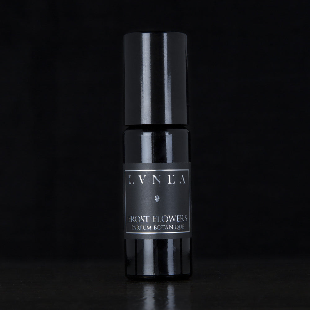 10ml black glass bottle of LVNEA's Frost Flowers natural roll on perfume oil on black background