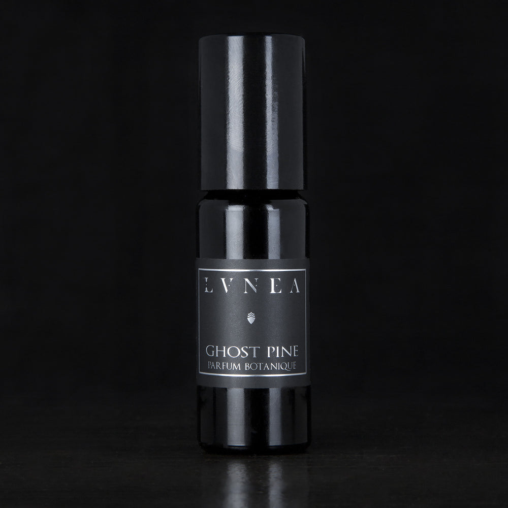 10ml black glass bottle of LVNEA's best-selling Ghost Pine roll on perfume oil on black background