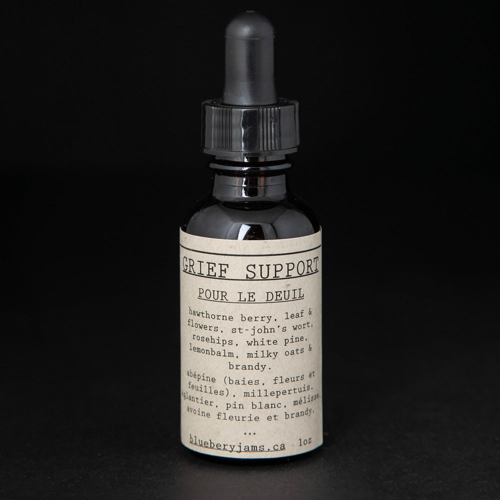 Black glass bottle with dropper top and tan label reading "Grief Support". The bottle contains a herbal tincture by blueberryjams.