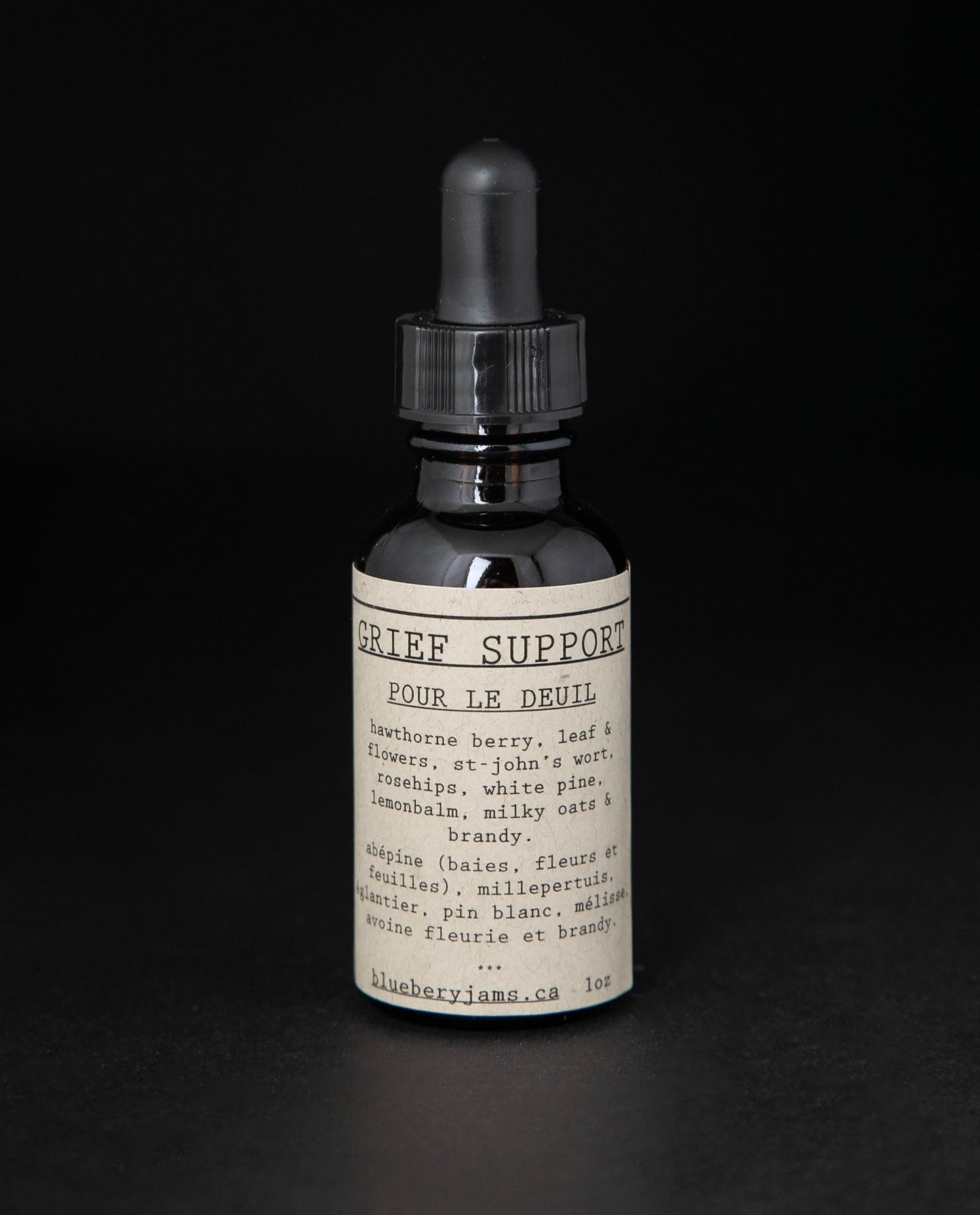 Black glass bottle with dropper top and tan label reading "Grief Support". The bottle contains a herbal tincture by blueberryjams.