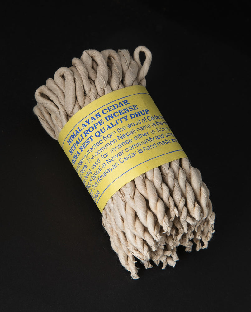 Bundle of himalayan cedar rope incense wrapped together with yellow paper label.