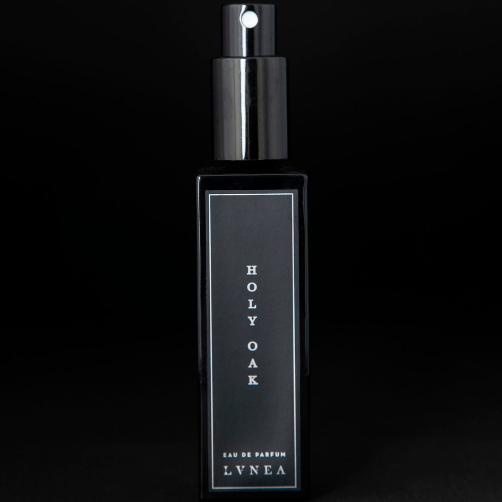 30ml black glass bottle of LVNEA’s Holy Oak natural perfume on black background. The lid is removed, exposing the bottle's spray top.