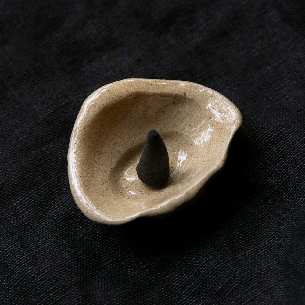 Small handmade stoneware dish with organic shape and clear glaze.