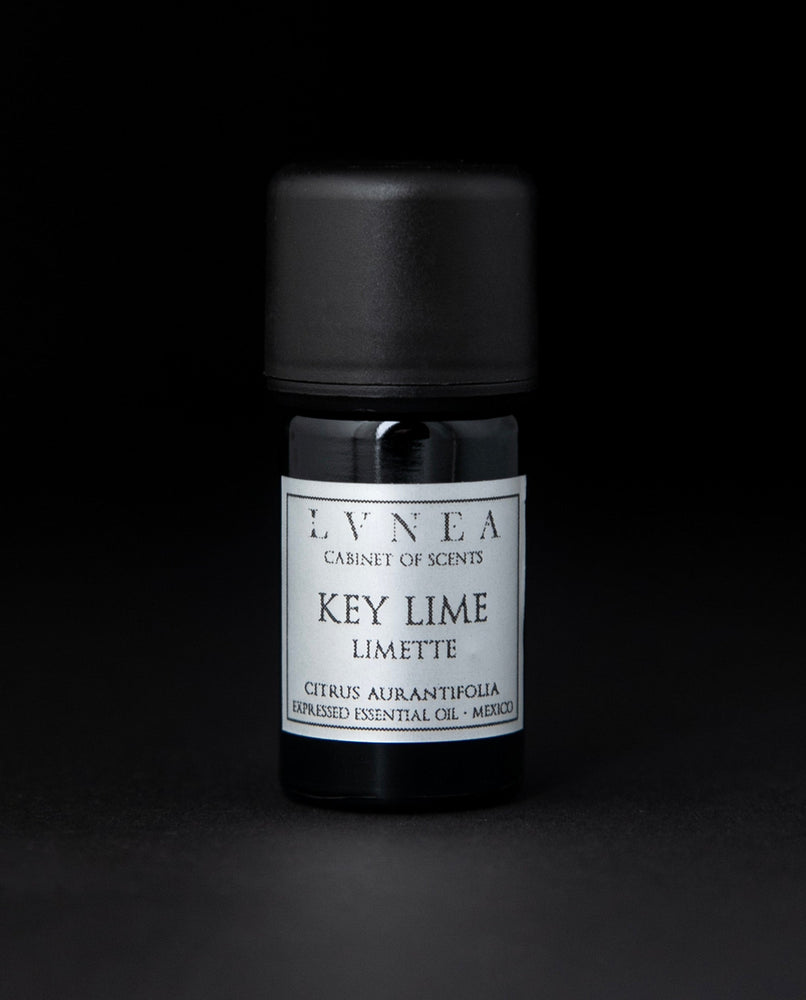 5ml black glass bottle of LVNEA's key lime essential oil on black background. The label on the bottle is silver.