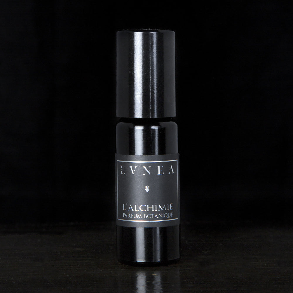 10ml black glass bottle of LVNEA's l'Alchimie natural roll on oil perfume on black background