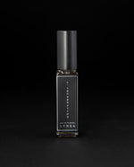 8ml clear glass bottle of LVNEA’s l'Incarnation natural perfume on black background