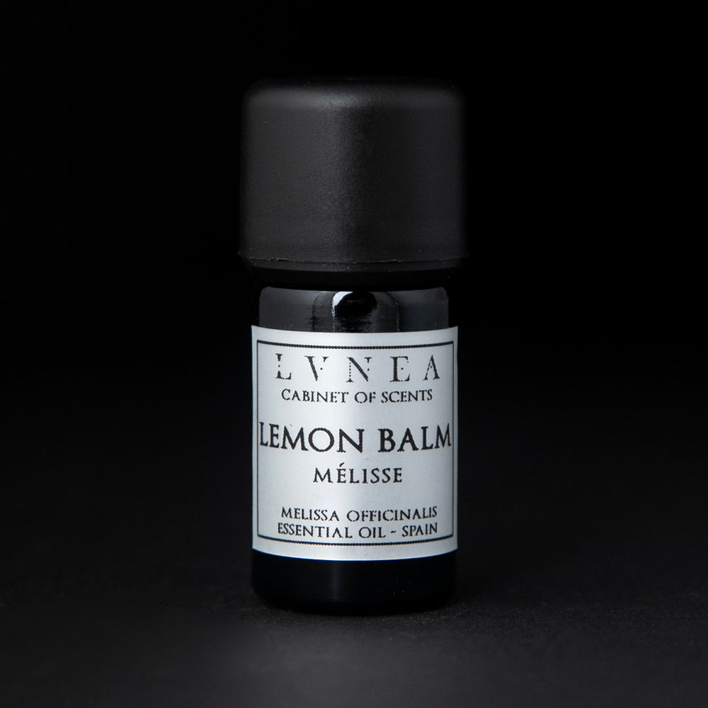 5ml black glass bottle of LVNEA's lemon balm essential oil on black background. The label on the bottle is silver.