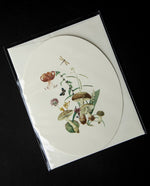 Cream-coloured oval card with vintage Victorian-style imagery of mushrooms and botanicals on the front. 