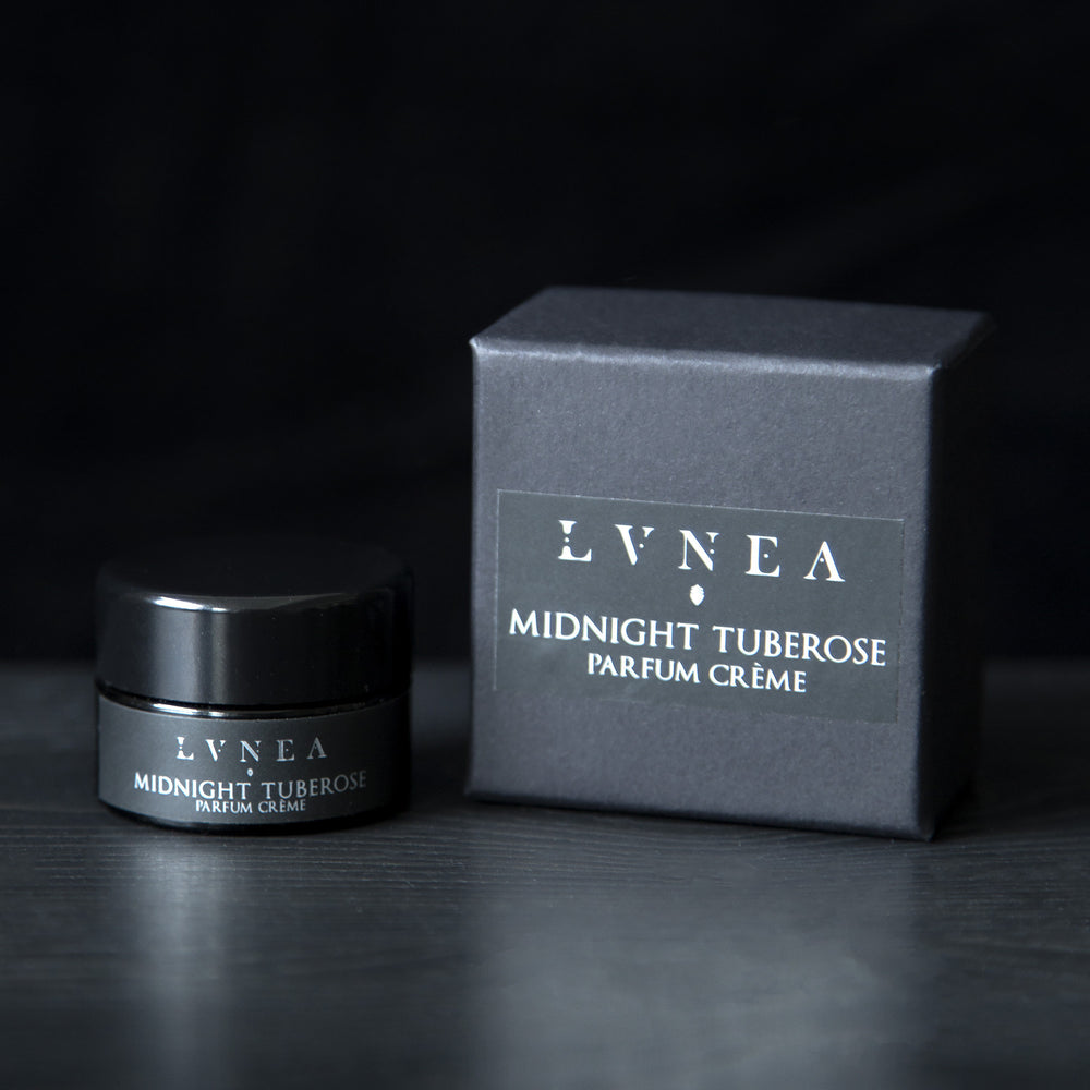 10g black glass jar of LVNEA's Midnight Tuberose solid perfume next to its box on black background