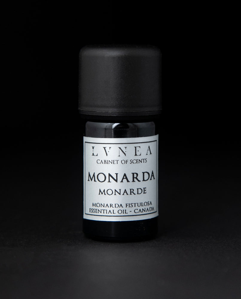 5ml black glass bottle of LVNEA's monarda essential oil on black background. The label on the bottle is silver.