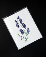 white greeting card featuring a botanical illustration of purple monkshood flowers