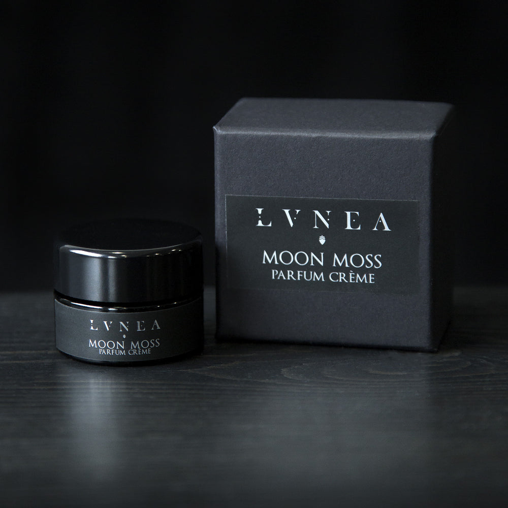 
                      
                        10g black glass jar of LVNEA's 'Moon Moss' vegan solid perfume, sitting next to its black box on a black wooden surface.
                      
                    