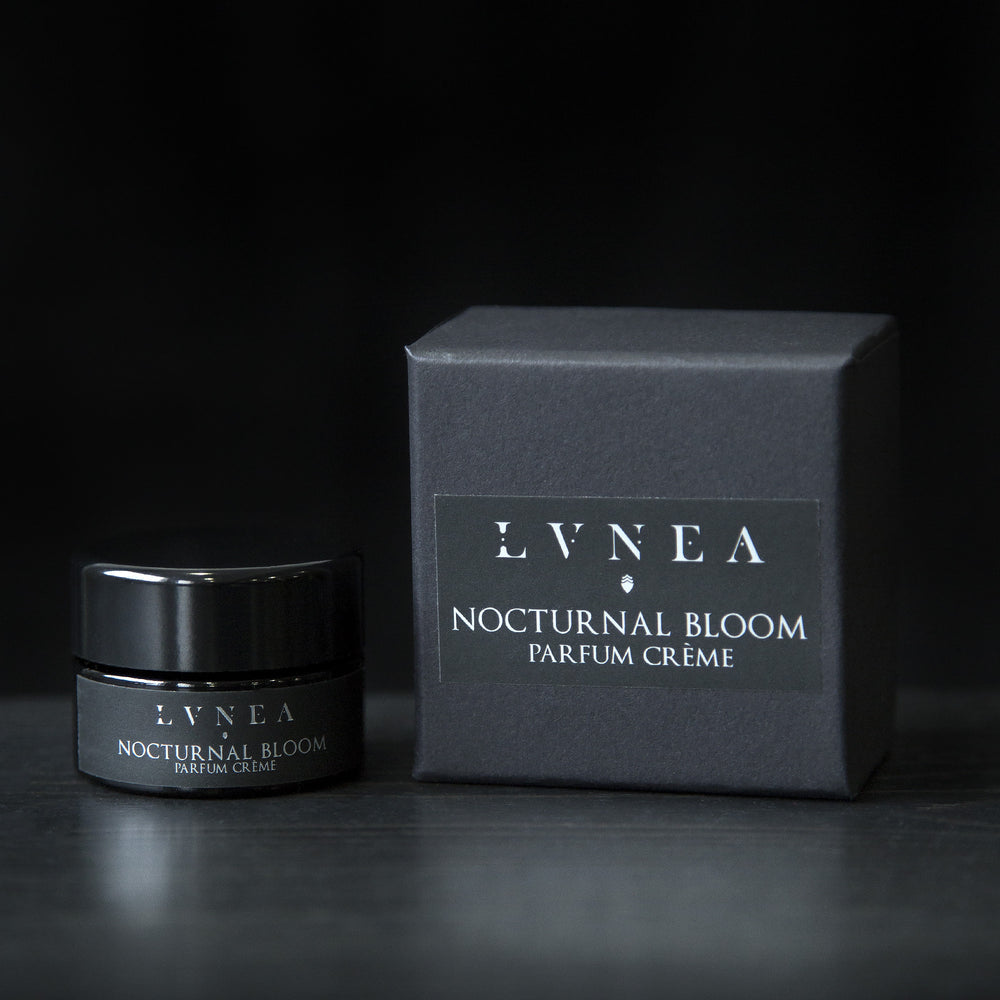 10g black glass pot of LVNEA's Nocturnal Bloom solid perfume next to its box on black background