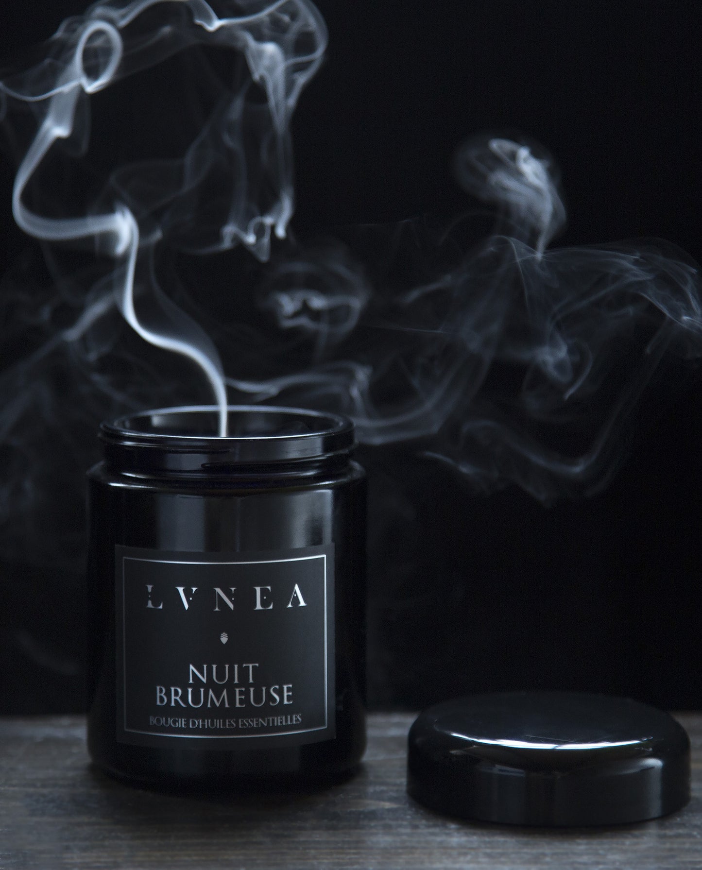 8 oz Nuit Brumeuse candle with lid removed. A plume of smoke is rising from the candle.