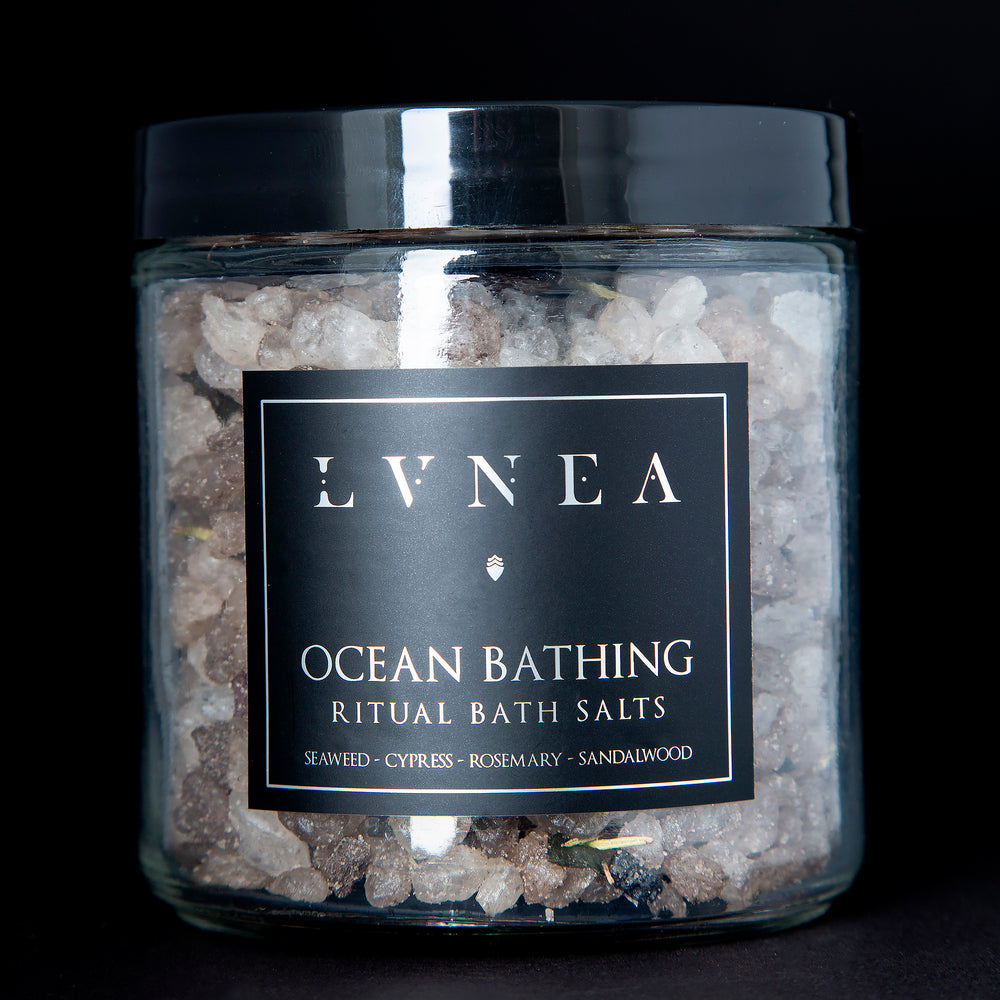 A clear 16 ounce jar filled with LVNEA's Ocean Bathing bath salts on black background