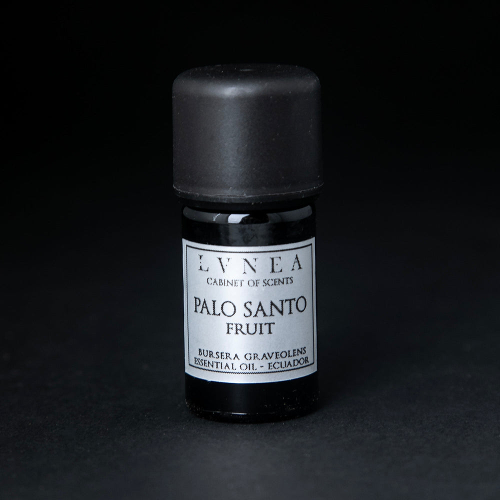 5ml black glass bottle of LVNEA's palo santo fruit essential oil on black background. The label on the bottle is silver.