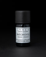 5ml black glass bottle of LVNEA's patchouli essential oil on black background. The label on the bottle is silver.