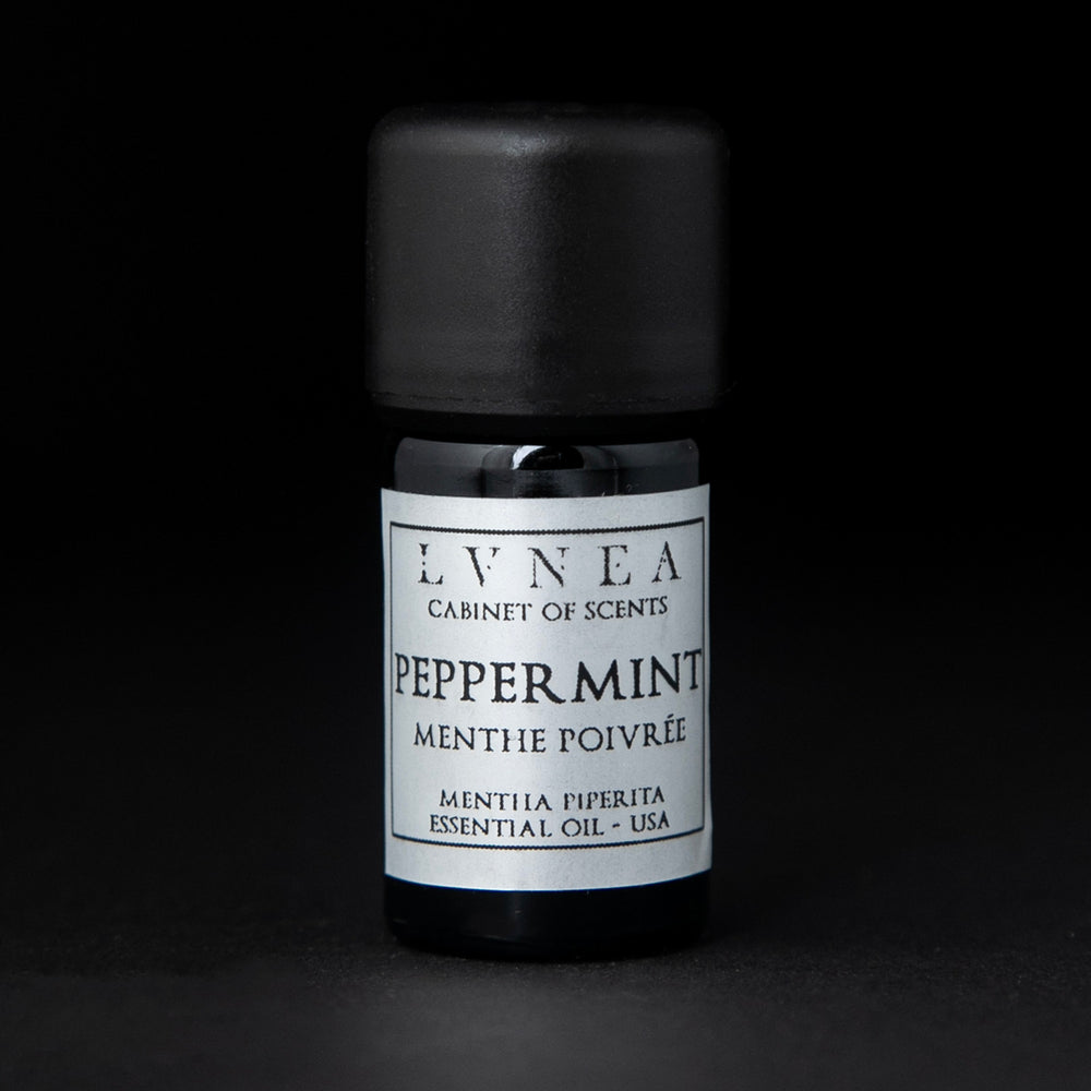 5ml black glass bottle of LVNEA's peppermint essential oil on black background. The label on the bottle is silver.