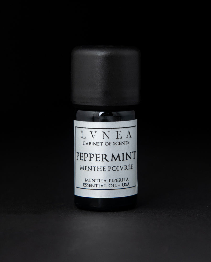 5ml black glass bottle of LVNEA's peppermint essential oil on black background. The label on the bottle is silver.