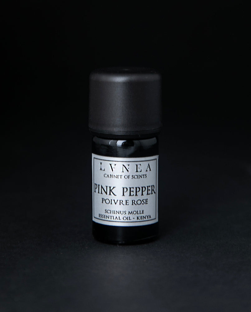 5ml black glass bottle of LVNEA's pink pepper essential oil on black background. The label on the bottle is silver.