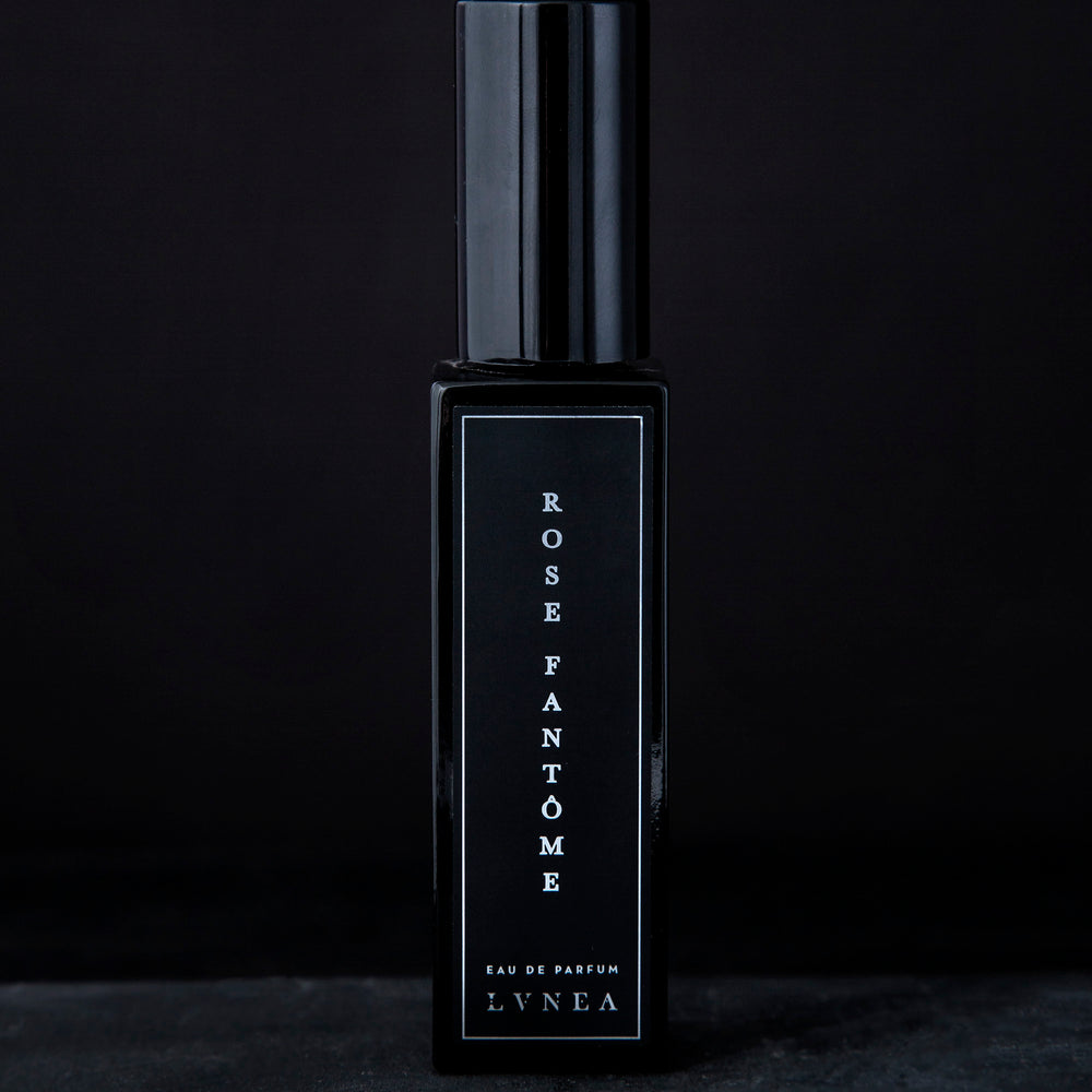 30ml black glass bottle of LVNEA’s Rose Fantôme natural perfume on black background
