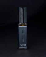 8ml clear glass bottle of LVNEA’s Rose Fantôme natural perfume on black background, bottle is rotated at a 3/4 angle exposing a star pattern on the label.