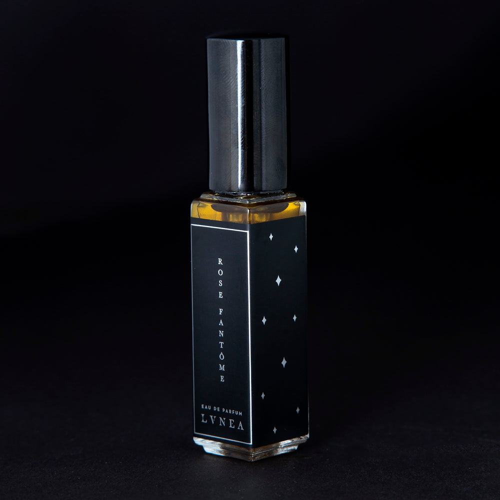 
                      
                        8ml clear glass bottle of LVNEA’s Rose Fantôme natural perfume on black background, bottle is rotated at a 3/4 angle exposing a star pattern on the label.
                      
                    