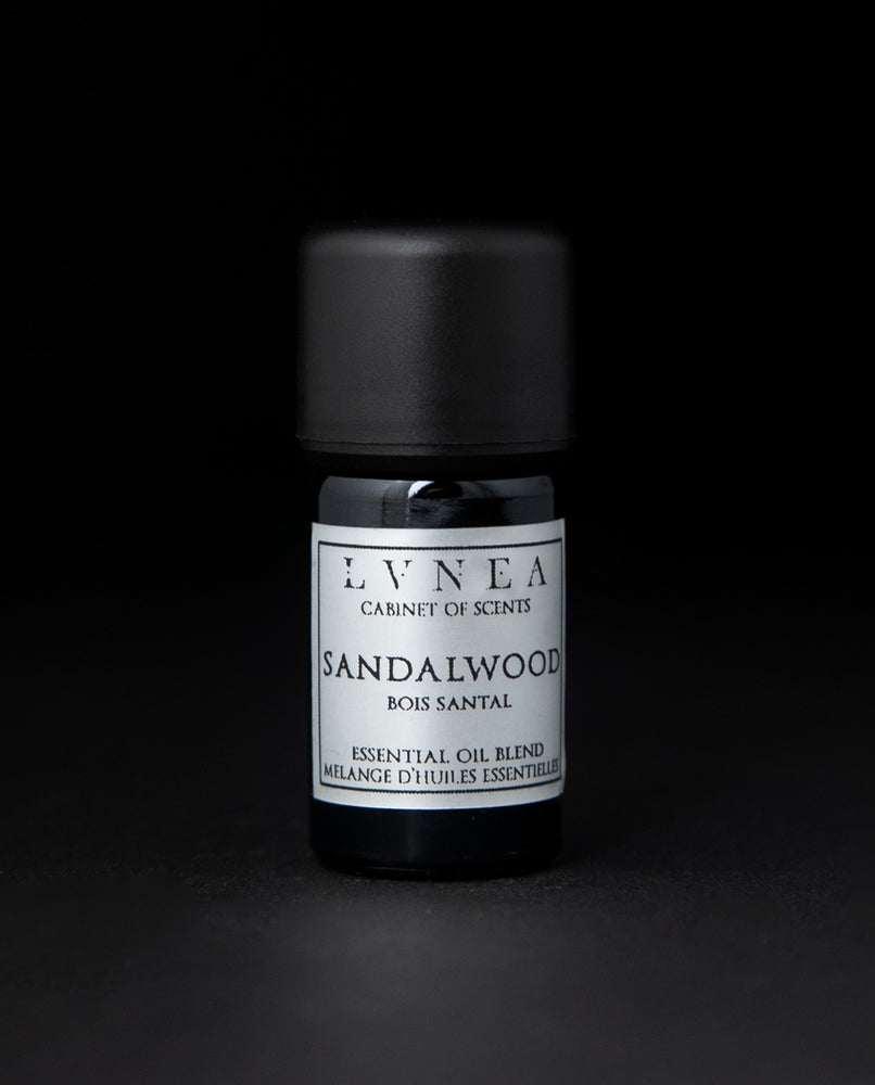 5ml black glass botttle of LVNEA's sandalwood essential oil on black background. The label on the bottle is silver.